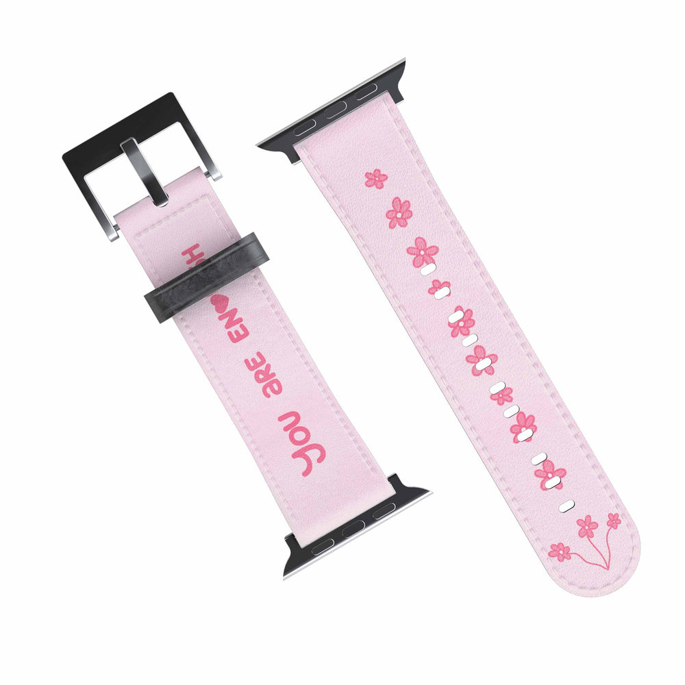 A pink Apple Watch band with white text and design, featuring a digital display on the watch face.